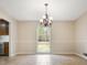 Traditional dining room with tile floors, chandelier, and a view of the backyard through a large window at 545 Bellemeade Sw Dr, Marietta, GA 30008