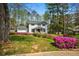 Beautiful white home with blooming azaleas, lush greenery, inviting front porch, and attached garage, creating curb appeal at 545 Bellemeade Sw Dr, Marietta, GA 30008