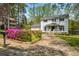 Charming two-story home with white siding, black shutters, and a beautifully landscaped front yard with colorful flowers at 545 Bellemeade Sw Dr, Marietta, GA 30008