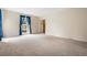 Large, carpeted living room featuring a bright window with blue curtains and a doorway leading to the foyer at 545 Bellemeade Sw Dr, Marietta, GA 30008