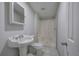 Clean bathroom with a pedestal sink, white shower, and tiled floors at 643 Tumlin Lake Rd, Temple, GA 30179