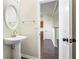 The powder room features a pedestal sink, round mirror and tile flooring at 109 Odyssey, Conyers, GA 30012