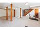The basement features carpeted floors, wooden columns, and a staircase at 4151 Valley Wood Nw Dr, Marietta, GA 30064