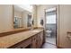 A bathroom with a long granite countertop, cabinets, a mirror, and a toilet in the other room at 4151 Valley Wood Nw Dr, Marietta, GA 30064