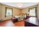 A cozy bedroom with laminate wood floors, neutral walls, a comfy bed and two windows at 4151 Valley Wood Nw Dr, Marietta, GA 30064