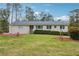Well-kept single-story home featuring a manicured lawn, tidy shrubbery, and neutral siding under a clear sky at 4151 Valley Wood Nw Dr, Marietta, GA 30064
