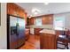 Modern kitchen with stainless steel appliances, cherry wood cabinets, granite countertops, and hardwood flooring at 4151 Valley Wood Nw Dr, Marietta, GA 30064