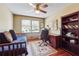 A functional office space featuring a desk, chair, bookshelf, and daybed, bathed in natural light at 4151 Valley Wood Nw Dr, Marietta, GA 30064