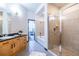 Well-lit bathroom featuring a vanity, bathtub-shower combo, glass-enclosed shower, and tile flooring at 5300 Peachtree Rd # 3206, Atlanta, GA 30341