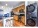 Contemporary kitchen featuring an island with seating, stainless steel appliances, and stacked washer/dryer at 5300 Peachtree Rd # 3206, Atlanta, GA 30341