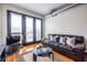 Living room with leather sofa, hardwood floors, and access to a balcony with natural light at 5300 Peachtree Rd # 3206, Atlanta, GA 30341