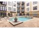 Beautiful outdoor pool with a fountain feature surrounded by lush landscaping and apartments with balconies at 5300 Peachtree Rd # 3206, Atlanta, GA 30341