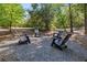 Charming backyard area with Adirondack chairs on a gravel area, surrounded by trees at 1337 Grey Fox Ne Ct, Atlanta, GA 30306
