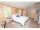 Bright bedroom with knotty pine walls, sliding barn door closet, and wood-look flooring at 418 Robinson Rd, Peachtree City, GA 30269