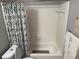 Functional bathroom featuring a shower-tub combo, neutral tiling, and coordinating accessories at 6490 Emerald Pointe Circle, Atlanta, GA 30349