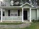 Charming single-story home features a covered porch and a black front door at 6490 Emerald Pointe Circle, Atlanta, GA 30349
