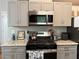 Updated kitchen features granite counters, stainless microwave, and gas range at 6490 Emerald Pointe Circle, Atlanta, GA 30349