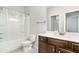 Well-lit bathroom featuring a vanity with dark cabinets, toilet, shower and tub at 3610 Central Park Dr, Loganville, GA 30052
