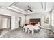 Neutral bedroom boasts tray ceilings, a ceiling fan, plush carpet, and two windows at 3610 Central Park Dr, Loganville, GA 30052