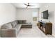 Comfortable bonus room with a sectional couch, carpet and a mounted television at 3610 Central Park Dr, Loganville, GA 30052