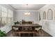 Formal dining room with modern chandelier, dark wood table, and neutral decor at 3610 Central Park Dr, Loganville, GA 30052