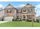 Charming two-story home with brick facade, a two-car garage, and a green lawn at 3610 Central Park Dr, Loganville, GA 30052