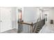 Upstairs hallway with wooden handrail and carpet, offering a glimpse into adjacent rooms at 3610 Central Park Dr, Loganville, GA 30052