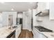 Open kitchen featuring granite countertops, stainless appliances, subway tile backsplash and center island at 3610 Central Park Dr, Loganville, GA 30052