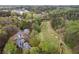 Stunning aerial view showcasing a home bordering a lush golf course, surrounded by mature trees and landscaping at 8207 Fairview Blf, Alpharetta, GA 30022