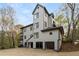 View of the rear exterior with multiple levels, balconies and a three-car garage at 8207 Fairview Blf, Alpharetta, GA 30022