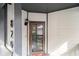Exterior front door view with the house number, a storm door, and painted wood siding at 8207 Fairview Blf, Alpharetta, GA 30022