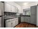 Modern kitchen with stainless steel appliances, beautiful backsplash, gray cabinets, and hardwood floors at 8207 Fairview Blf, Alpharetta, GA 30022