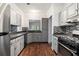 Well-equipped kitchen featuring stainless appliances, gray cabinetry, tile backsplash and hardwood floors at 8207 Fairview Blf, Alpharetta, GA 30022
