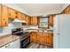 Functional kitchen with wooden cabinets, modern stove, and stainless-steel appliances at 1105 S Parkwood Dr, Forest Park, GA 30297