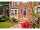 Charming brick home with a welcoming red door, bay window, and well-maintained front yard with colorful flowers at 3100 Queens Ne Walk, Atlanta, GA 30345