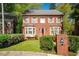 Charming two-story brick home featuring a landscaped front yard and a vibrant red front door at 3100 Queens Ne Walk, Atlanta, GA 30345