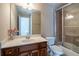 Bathroom featuring a vanity with a granite countertop, mirror, and a shower with glass doors at 5650 Upper Creek Ct, Suwanee, GA 30024