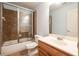 Bathroom featuring a shower over tub with glass doors, a vanity, and neutral tile flooring at 5650 Upper Creek Ct, Suwanee, GA 30024