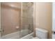 Clean, tiled bathroom featuring a shower-tub combo with glass doors, toilet, and vanity at 5650 Upper Creek Ct, Suwanee, GA 30024