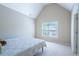 Bright bedroom featuring a large window, vaulted ceiling, and neutral decor at 5650 Upper Creek Ct, Suwanee, GA 30024