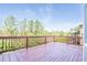 Exterior wooden deck, with brown railing, offers stunning views of green trees, neighborhood, and blue skies at 5650 Upper Creek Ct, Suwanee, GA 30024