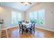 Bright dining area featuring a vaulted ceiling and three windows, accompanied by hardwood floors at 5650 Upper Creek Ct, Suwanee, GA 30024