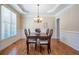 Elegant dining room with hardwood floors, tray ceilings, and a chandelier over a wooden table at 5650 Upper Creek Ct, Suwanee, GA 30024