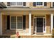 Close-up of a beautiful brick home's front door with black shutters and white trim at 5650 Upper Creek Ct, Suwanee, GA 30024