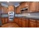 Kitchen area features wooden cabinets, stainless steel appliances, granite countertops, and hardwood flooring at 5650 Upper Creek Ct, Suwanee, GA 30024