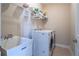 Bright laundry room includes washer, dryer, utility sink and shelving, with ceramic tile flooring at 5650 Upper Creek Ct, Suwanee, GA 30024