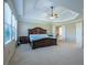 Spacious main bedroom featuring a coffered ceiling, ceiling fan, large windows, and a large bed at 5650 Upper Creek Ct, Suwanee, GA 30024