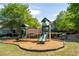Community playground featuring two slides, a bridge and lots of mulch, framed by shady trees at 5650 Upper Creek Ct, Suwanee, GA 30024