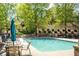 A view of the community pool, featuring a table with an umbrella and multiple lounge chairs at 5650 Upper Creek Ct, Suwanee, GA 30024
