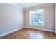 Bright room featuring hardwood floors, neutral walls, and a large window offering natural light at 5650 Upper Creek Ct, Suwanee, GA 30024